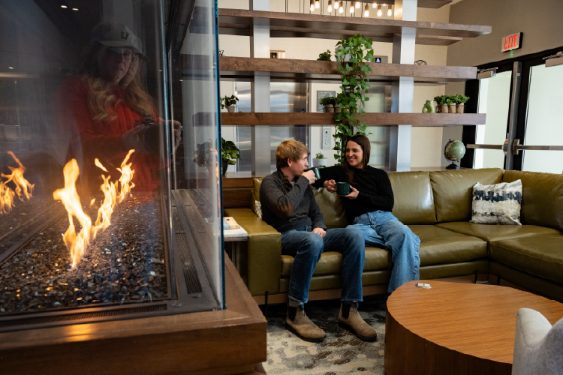 A couple sitting on a couch in a hotel in Belgrade, enjoying coffee together