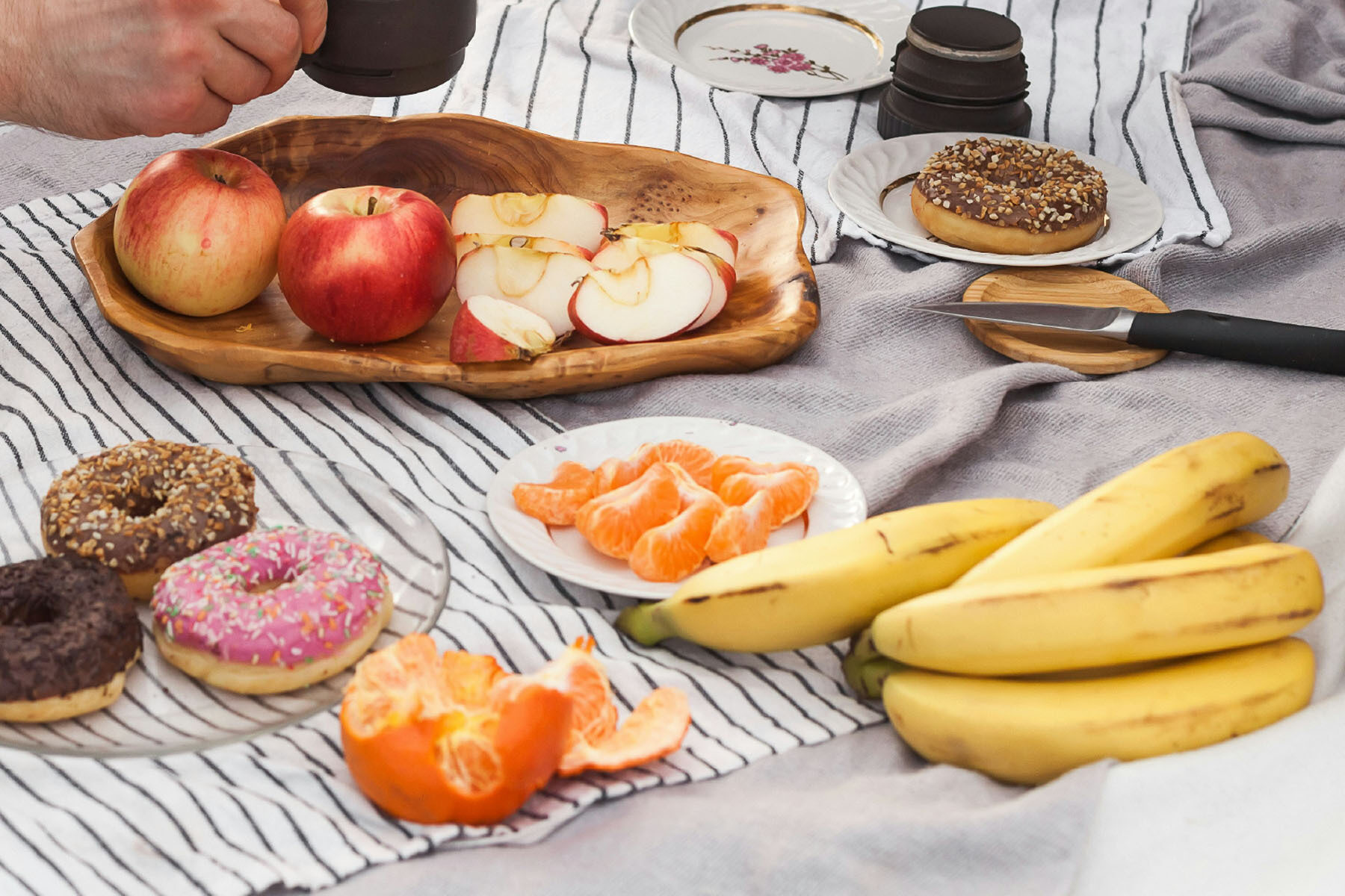 Fruit, donuts, and coffee on a blanket