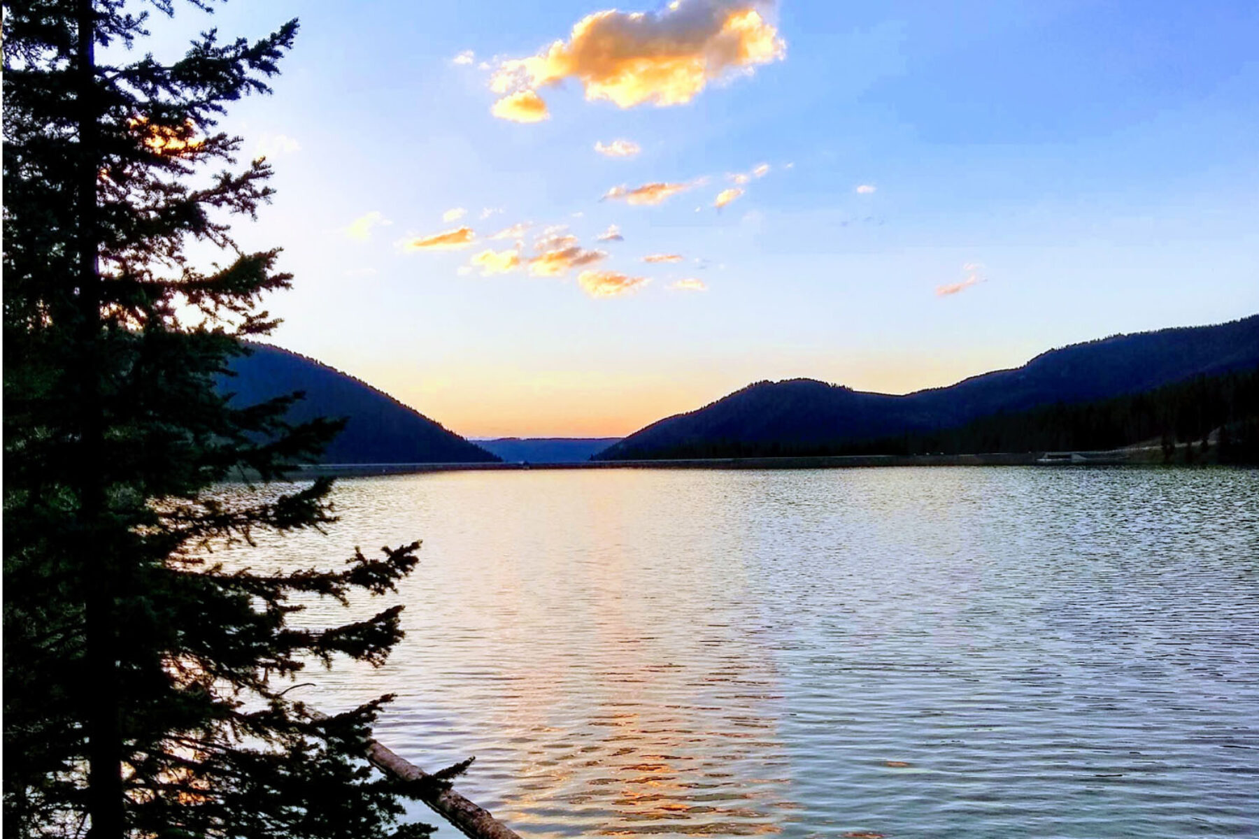 Sunset over a lake with mountains in the background