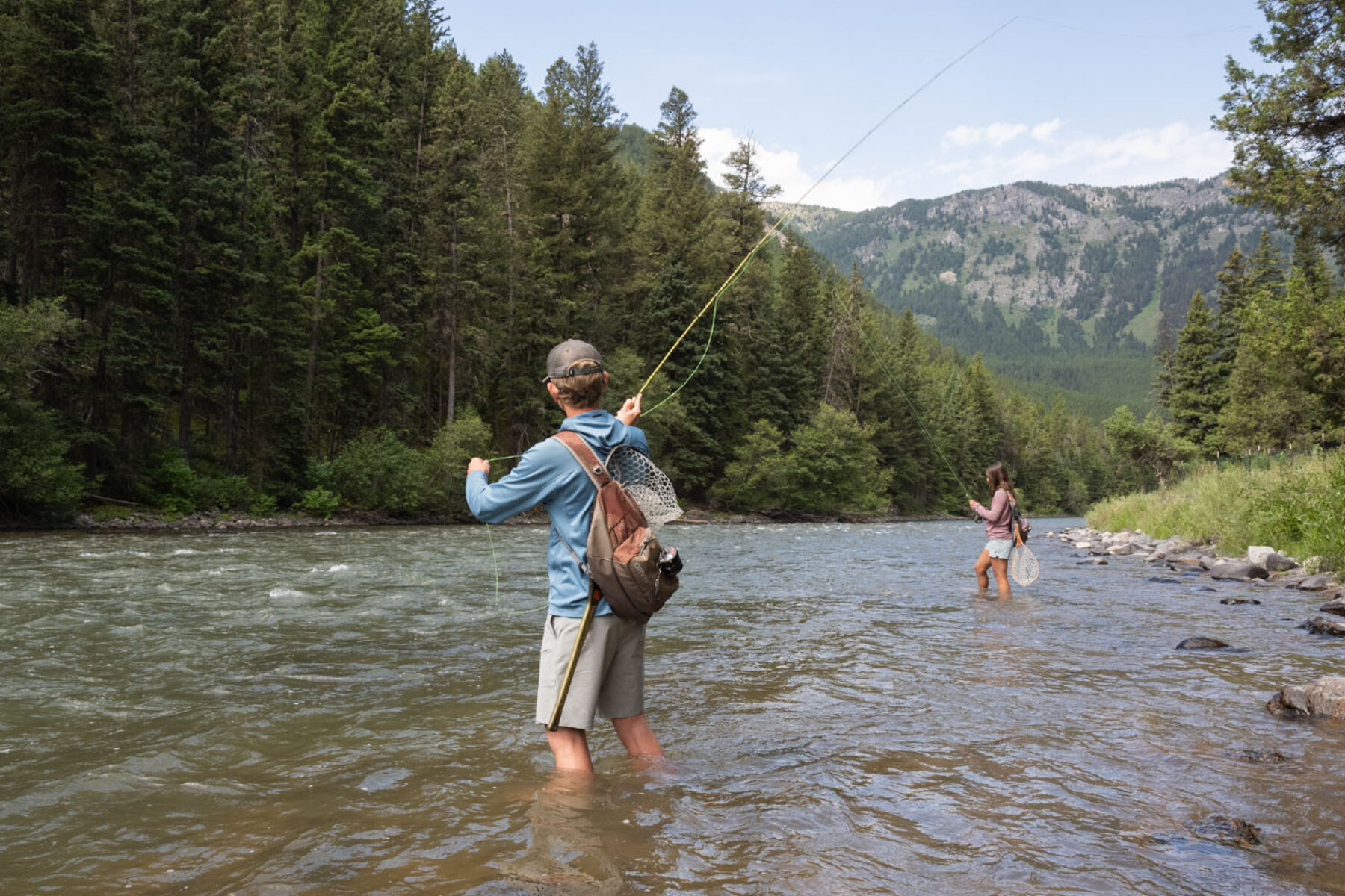 Man and woman wading and fly fishing on the Gallatin River